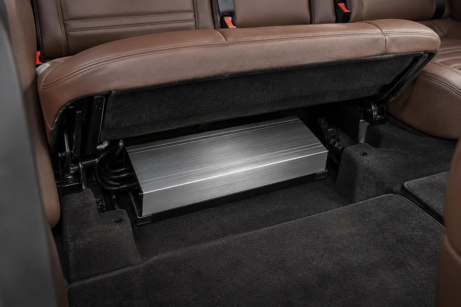 A slim amplifier under a lifted rear seat cushion